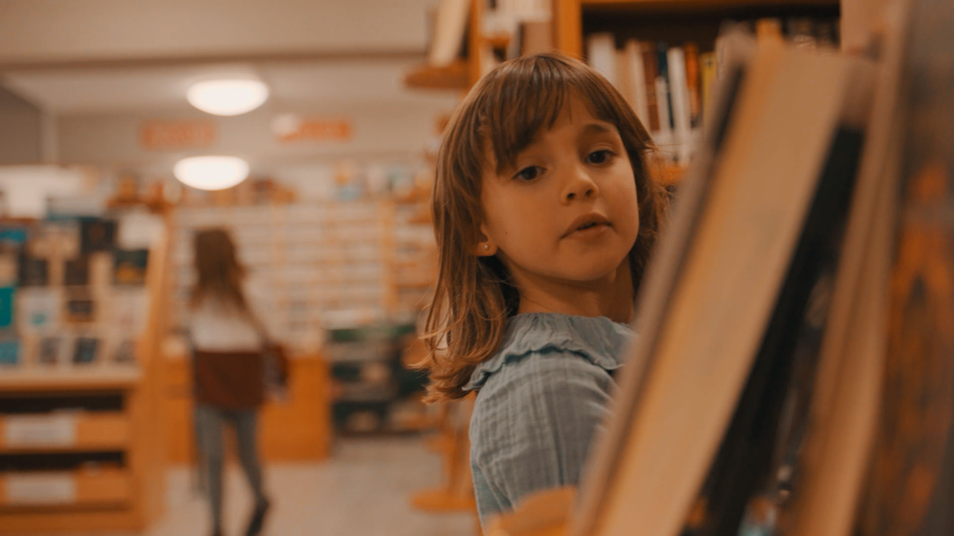 Niña entre las estanterías de una biblioteca