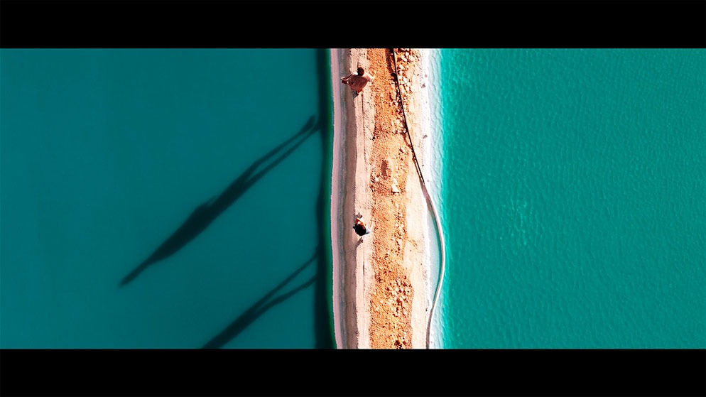 Vista aérea de un pequeño camino entre dos zonas de agua